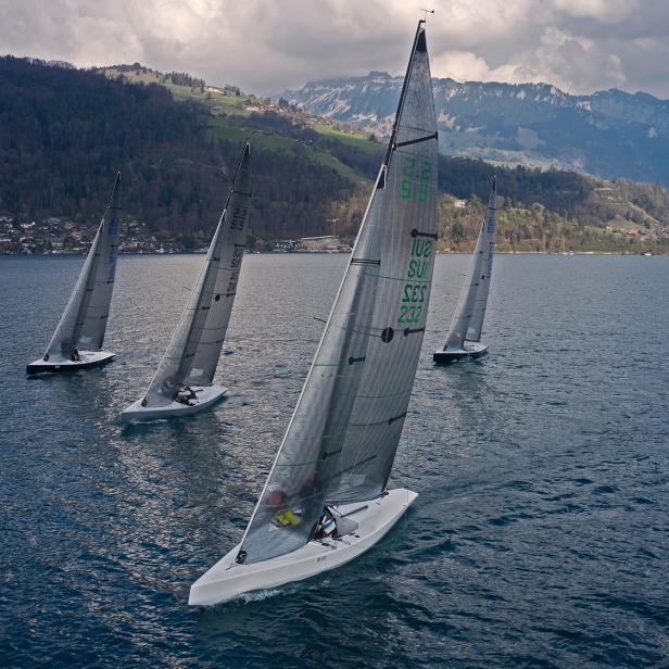 Vier Segelboote auf dem Wasser an einem bewölkten Tag.