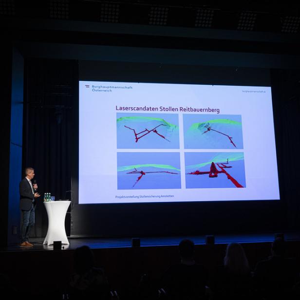 Mann präsentiert Laserscans der Stollenanlagen Reitbauernberg auf einer Bühne vor Publikum.