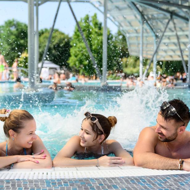 Mutter, Tochter und Vater entspannen in einem Indoor-Pool 
