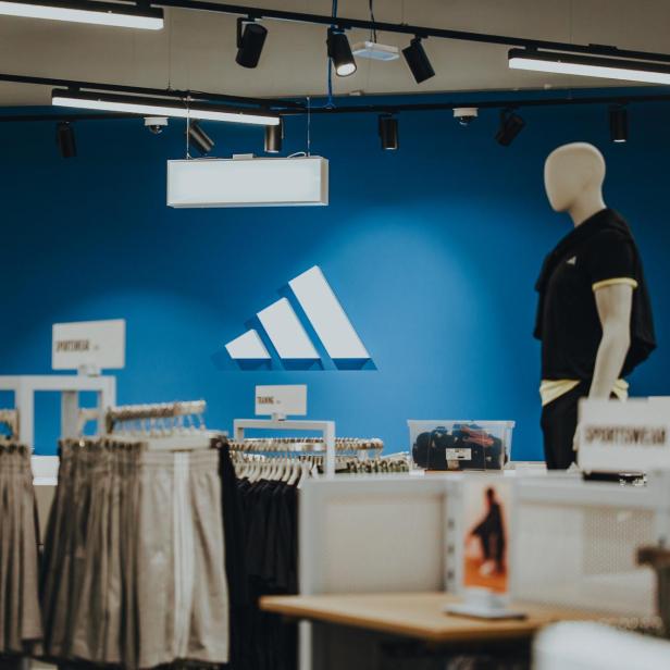 Innenansicht einer adidas Filiale, zeigt das markante Logo und eine ansprechende Produktpräsentation.