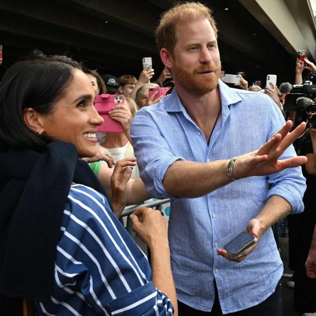 Meghan und Harry umgeben von Menschen und Kameras.