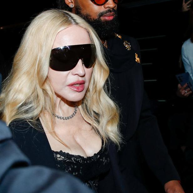 Madonna trägt übergroße Sonnenbrille und wird von einem Mann begleitet.