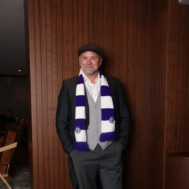 Thomas Stipsits mit einem weiß-violett-gestreiften Schal