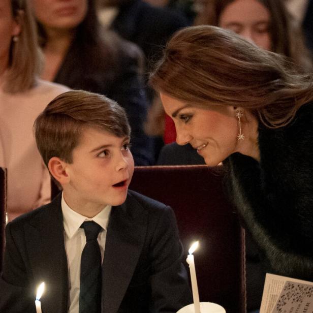 Prinzessin Kate und Prinz Louis im Anzug sitzen nebeneinander, halten Kerzen und lächeln sich während einer festlichen Zeremonie an.