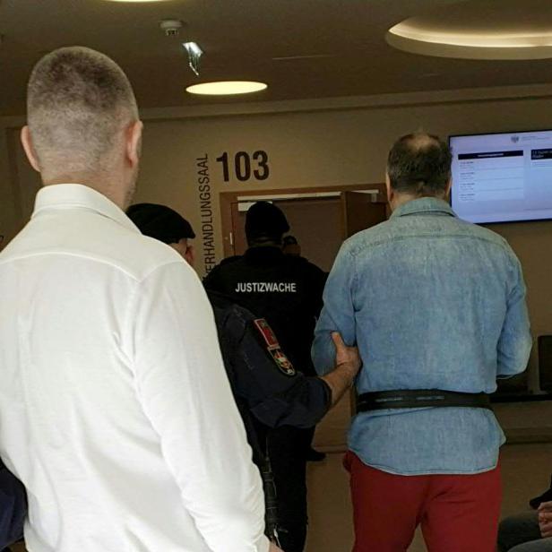 Zwei mutmaßliche Mitglieder des Kavač-Clans werden von Justizwachebeamten in Handschellen zum Verhandlungssaal im Wiener Landesgericht geführt.