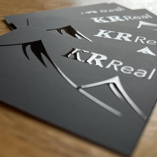 Visitenkarten mit dem Logo von K R Real, professionell gestaltet.