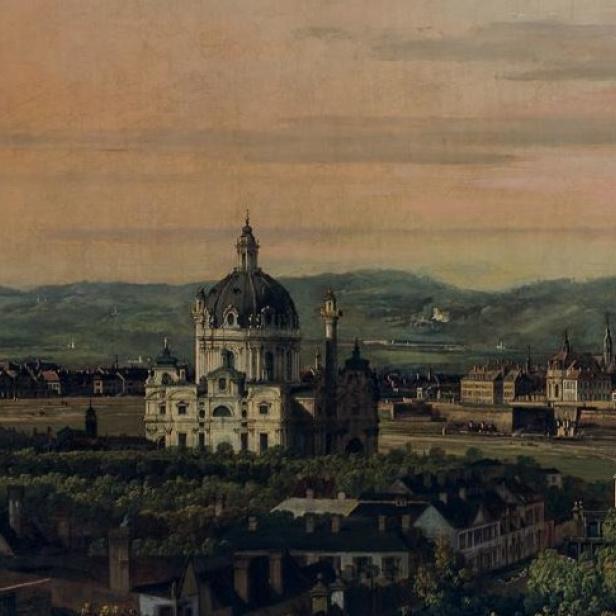 Große barocke Kirche mit Kuppel inmitten einer Stadtlandschaft, umgeben von Bäumen und Gebäuden bei Sonnenuntergang.
