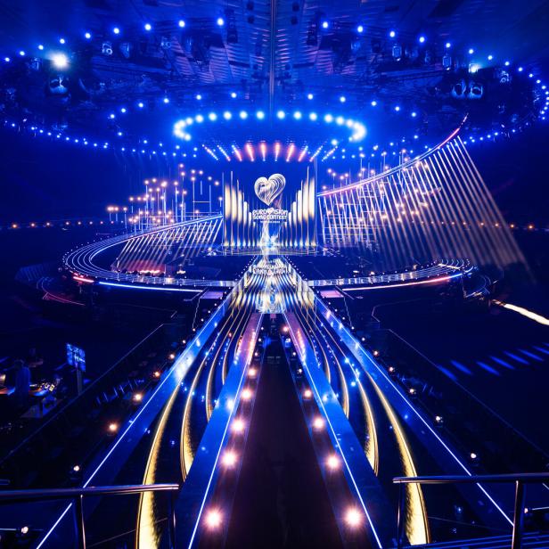 Große, futuristische Bühne mit vielen blauen Lichtern und dem Eurovision Song Contest Logo im Hintergrund.