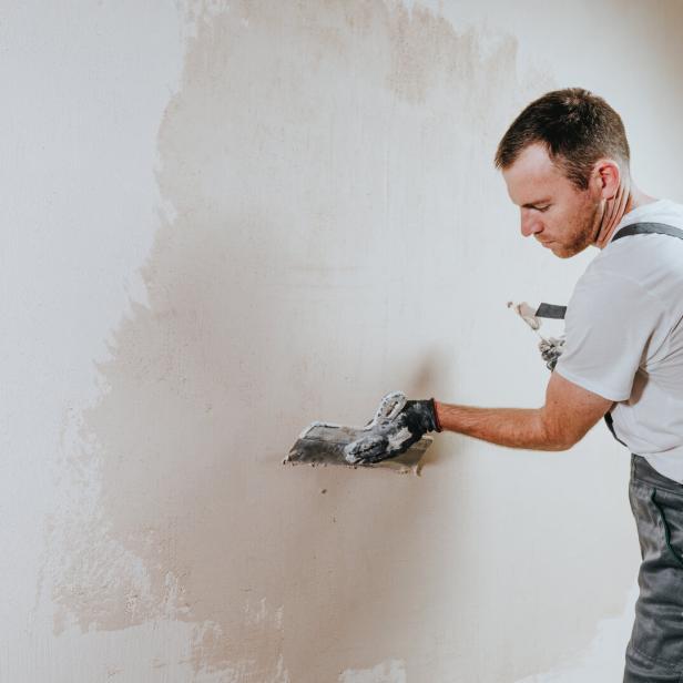Arbeiter verputzt Wand