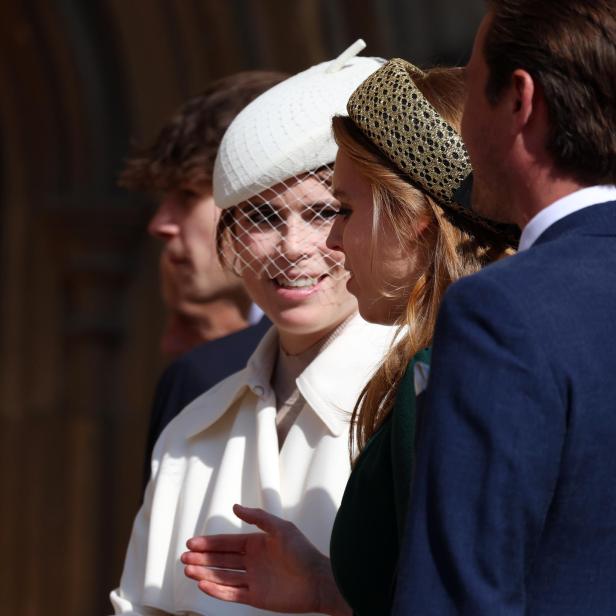 Beatrice und Eugenie mit Hüten unterhalten sich, eine trägt einen weißen Hut mit Schleier.