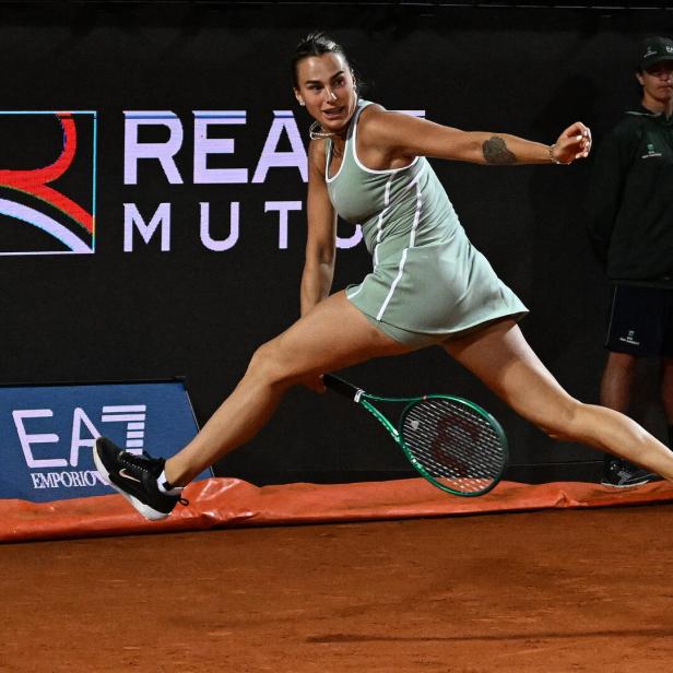 Aryna Sabalenka spielt einen Ball zwischen ihren Beinen durch.