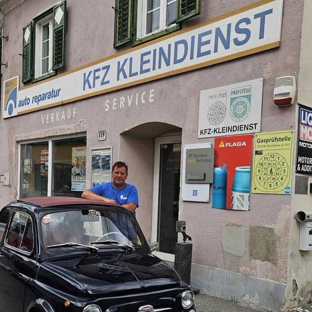 Ein Auto mit einem Mann vor einem Haus 