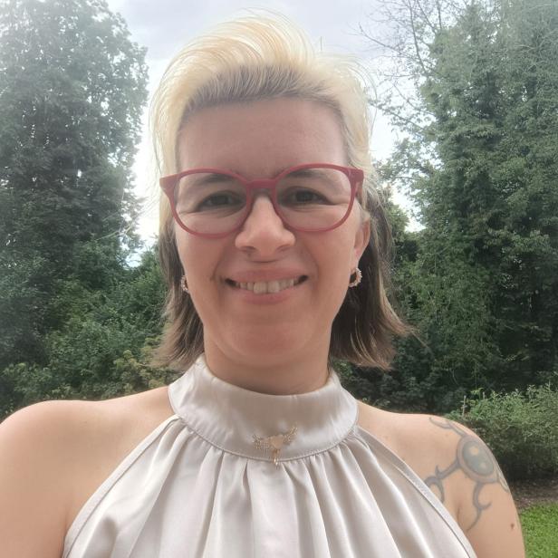 Eine blonde Frau mit kurzen Haaren und Brille 