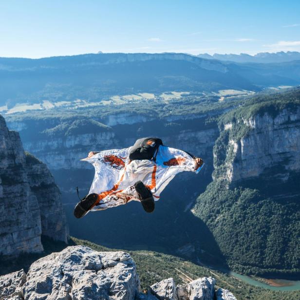 Basejumper springt in Abgrund vor Bergpanorama