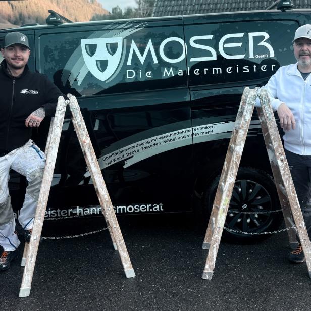 Zwei Handwerker in Arbeitskleidung stehen neben Leitern vor einem Firmenwagen mit der Aufschrift „Moser Die Malermeister“.