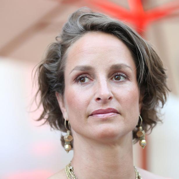 Lara Joy Körner mit kurzen gewellten Haaren blickt nachdenklich nach links.