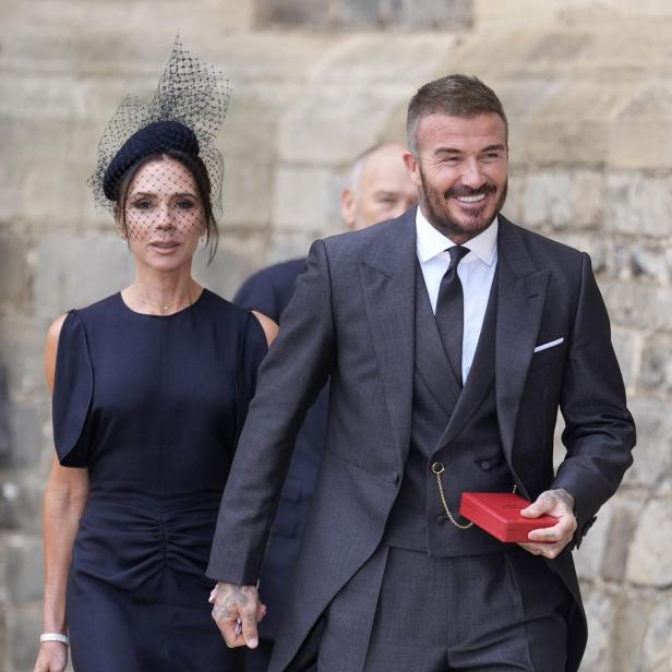 David und Victoria Beckham, elegant gekleidet, halten Händchen.