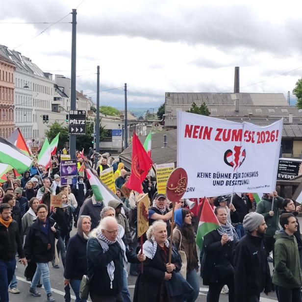 Demonstrierende Menschen mit palästinensischen Fahnen und Transparenten protestieren gemeinsam auf einer Straße.