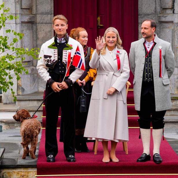 Die norwegische Königsfamilie, darunter Kronprinz Haakon und Kronprinzessin Mette-Marit, steht vor einem Gebäude.