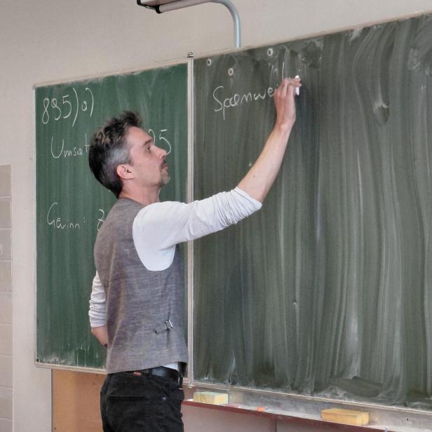 Lehrer schreibt auf Tafel