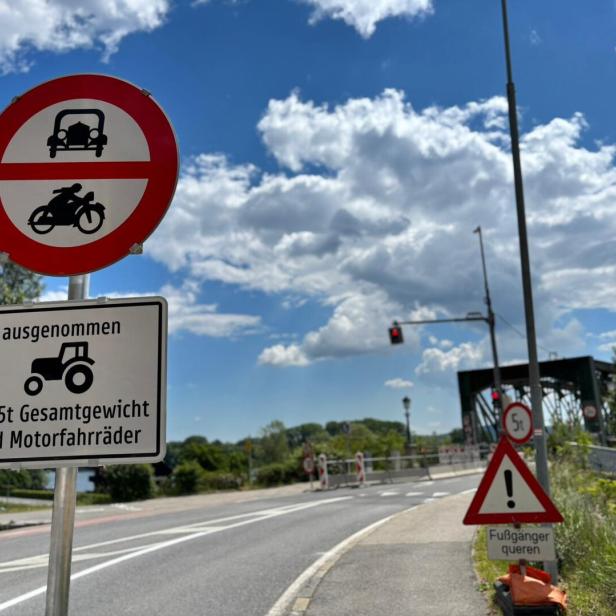Verkehrsschilder verbieten Autos und Motorräder, ausgenommen Traktoren bis 5 Tonnen und Motorfahräder, mit Hinweis auf querende Fußgänger.