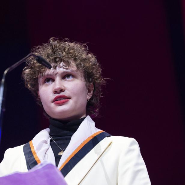 Luna Jordan mit lockigem Haar spricht am Rednerpult.