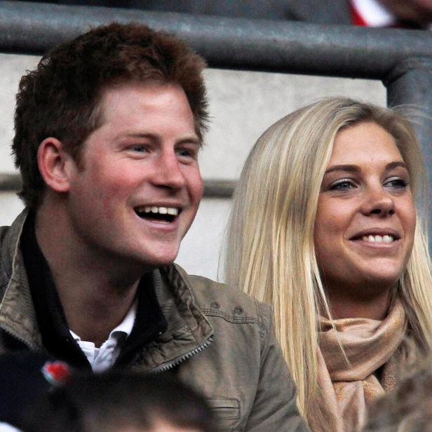 Prinz Harry und Chelsy Davy lächeln auf einer Tribüne.