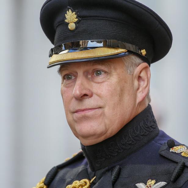 Andrew Mountbatten-Windsor in Uniform mit schwarzer Mütze und goldenen Verzierungen blickt zur Seite.