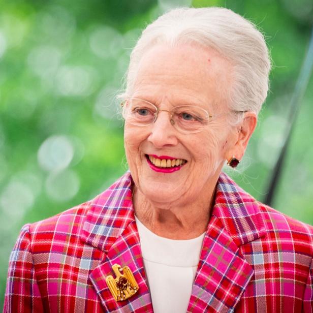 Altkönigin Margrethe II. lächelt in einem karierten Blazer mit einer goldenen Brosche.