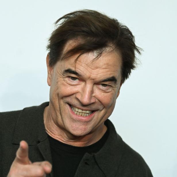 Ein lächelnder Campino mit braunen Haaren zeigt mit dem Finger nach vorne.