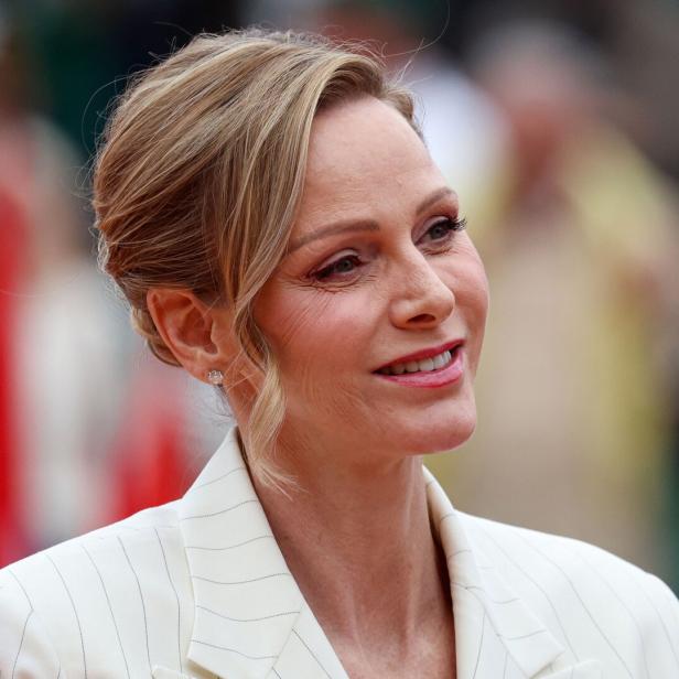 Fürstin Charlène lächelt in einem hellen Blazer mit dezentem Schmuck.
