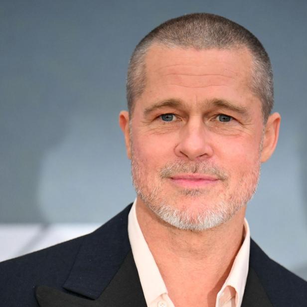 Brad Pitt mit kurzem, grau meliertem Haar und Bart trägt ein dunkles Jackett.