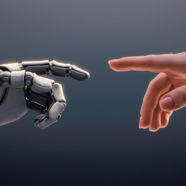 Eine menschliche Hand und eine Roboterhand nähern sich einander mit ausgestreckten Zeigefingern.