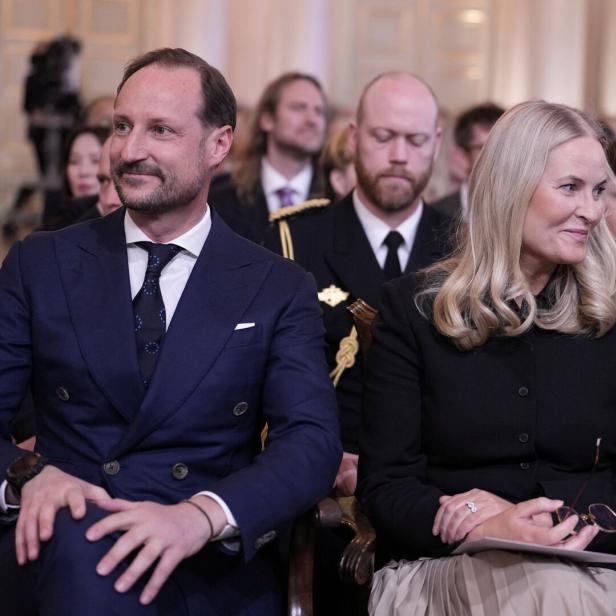 Kronprinz Haakon und Kronprinzessin Mette-Marit sitzen mit anderen Gästen bei einer Veranstaltung.