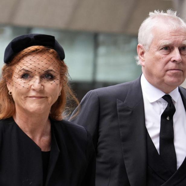 Sarah Ferguson und Prinz Andrew in dunkler Kleidung, die Herzogin mit Schleier, blicken ernst.