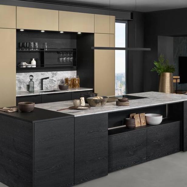 Eine moderne Küche mit dunklen Holzelementen, einer Marmorarbeitsplatte und goldenen Akzenten.