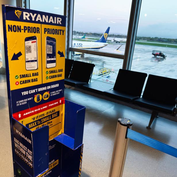 Ryanair signage at Manchester Airport waiting area with planes outside window