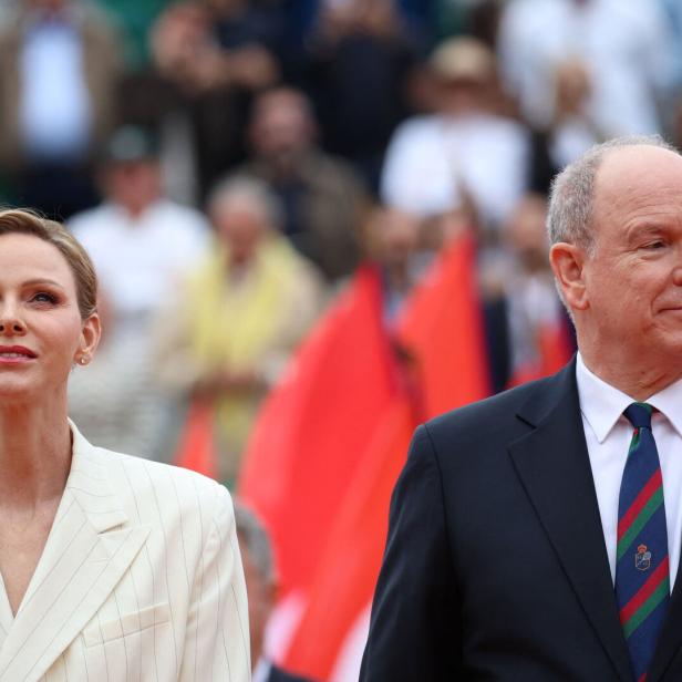 Fürst Albert II. und Fürstin Charlène von Monaco vor unscharfem Publikum.