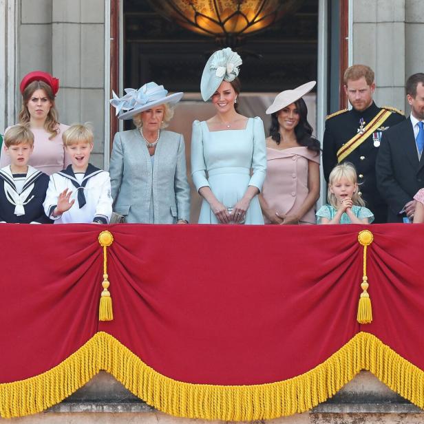 Auf einem Balkon stehen Mitglieder der königlichen Familie, darunter Kate, Meghan und Harry.