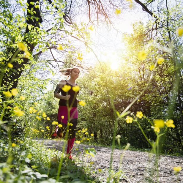 Young sporty woman jogging through the forest.