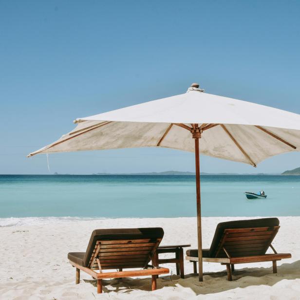 Liegen am Strand unter einem Sonnenschirm 