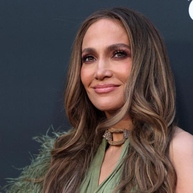 Jennifer Lopez mit langen Haaren lächelt und trägt ein grünes Kleid