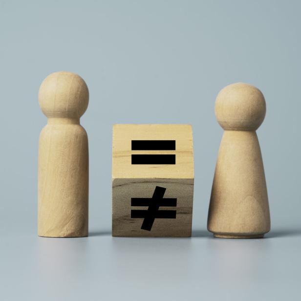 Flipping of unequal to equal sign between man and woman wooden figure. Human and business right concept.