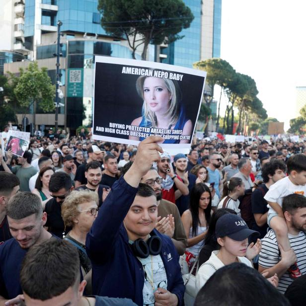 Eine Person hält bei einer Demonstration ein Schild mit einem Foto von Ivanka Trump und der Aufschrift „American Nepo Baby“ in die Höhe.