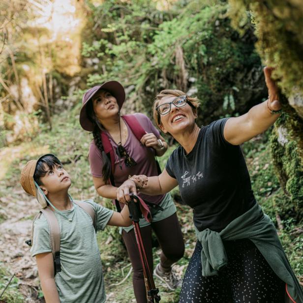 Eine Gastgeberin zeigt zwei Gästen beim Wandern in der Natur von Gorski Kotar besondere Plätze abseits der bekannten Wege.