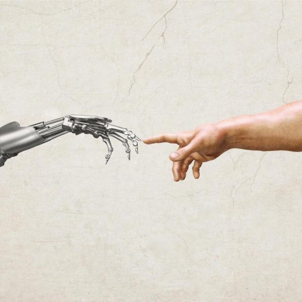 Ein menschlicher Arm und eine Roboterhand berühren sich fast mit ausgestrecktem Zeigefinger vor hellem Hintergrund.