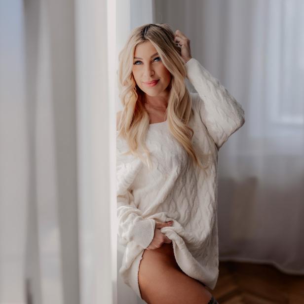 Eine blonde Frau in einem weißen Raum 