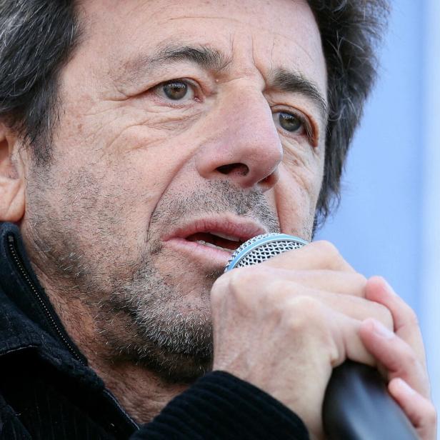 Patrick Bruel spricht in ein Mikrofon.