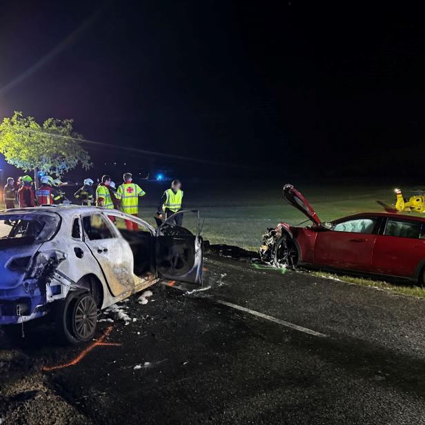 Zwei stark beschädigte Autos nach einem nächtlichen Unfall, Einsatzkräfte und ein Rettungshubschrauber sind vor Ort.