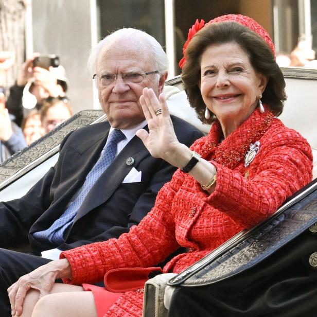 König Carl XVI. Gustaf und Königin Silvia von Schweden winken in einer Kutsche der Öffentlichkeit zu.
